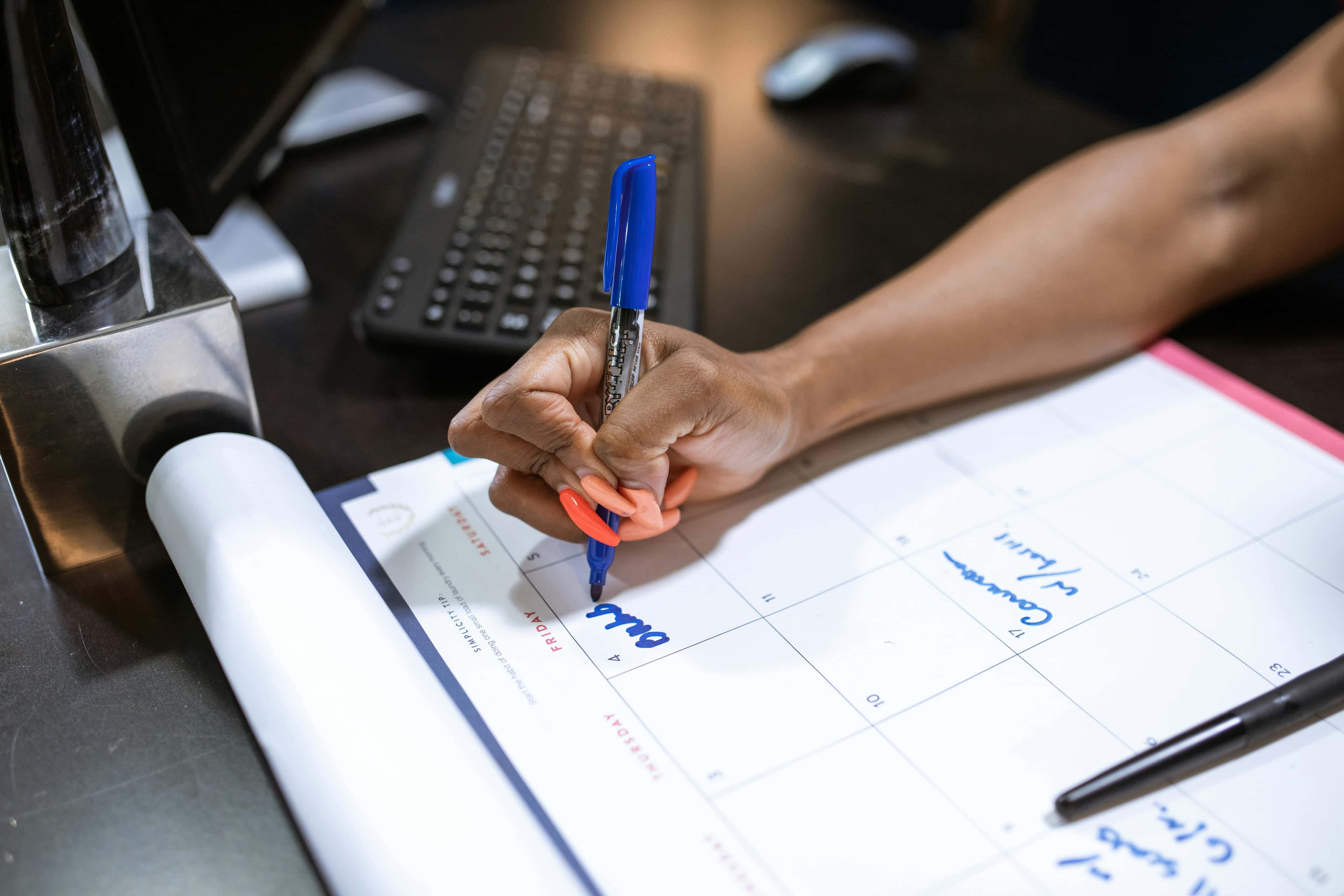Person writing a shift plan on a calendar