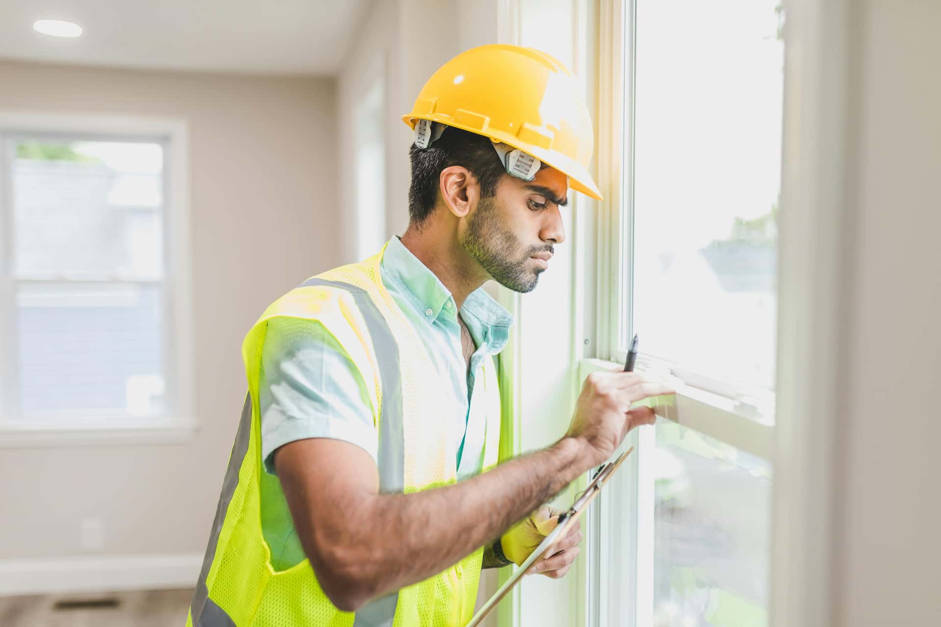 Construction worker checking a house window